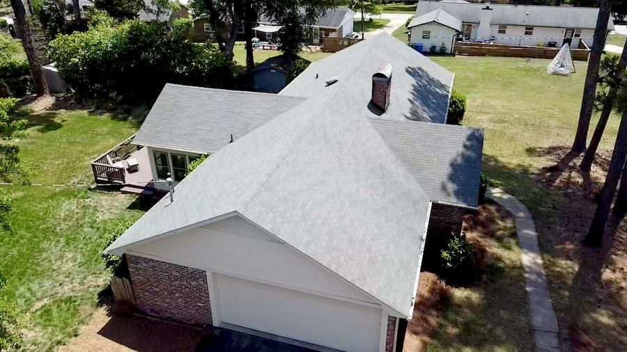 Drone view of a finished roof cleaning showing an even light gray shingle roof