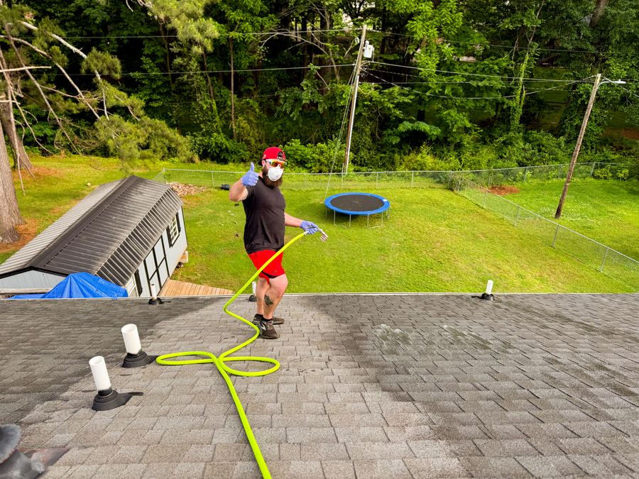 Moss Free technician giving a thumbs up while soft washing a roof in Upstate South Carolina