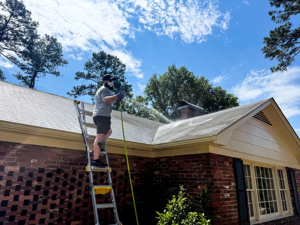 Roof cleaning in progress on a brick ranch home near Spartanburg, South Carolina