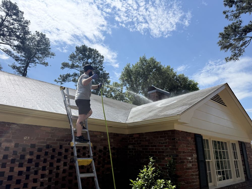 Soft wash equipment in use on the roof and eaves of a home in Upstate South Carolina